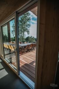 a sliding glass door to a deck with a table and chairs at Le Noir Flohay 30 pers - Malmedy, vue, wellness in Malmedy