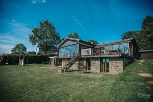 a large house with a deck and a balcony at Le Noir Flohay 30 pers - Malmedy, vue, wellness in Malmedy