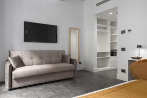 a living room with a couch and a tv on a wall at Magia di Firenze in Florence