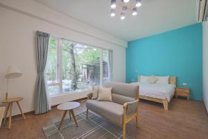 a bedroom with a couch and a bed and a window at OwlStay Green Villa in Pinghe
