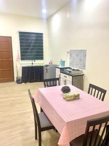 a kitchen with a table with a pink table cloth on it at ZHomestay - Malay Only in Gemas