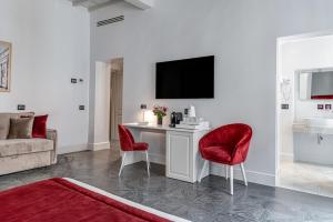 a living room with a desk and two red chairs at Magia di Firenze in Florence +18 photos