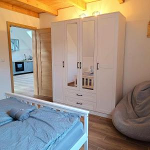 1 dormitorio con armario blanco y cama en Apartament Podgórzyn, en Podgórzyn