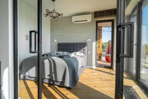 a bedroom with a bed and a sliding glass door at ViP PRATUM in Mikołajki +155 photos