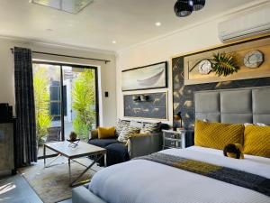una camera da letto con un letto e un divano di 24 On Basil Boutique Luxury Hotel a Johannesburg