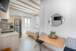 a kitchen and dining room with a table and a mirror at Perla's Luxury Apartments in Livadi