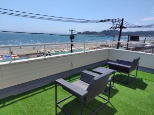 balcone con sedie, tavolo e vista sulla spiaggia di Zaimokuza SOLA 鎌倉材木座 a Kamakura