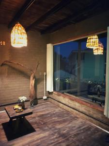 a porch with a table and a large window at Sa Moc & La Maison SAPA - Bungalows in Sa Pa