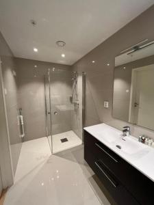 a bathroom with a shower and a sink and a mirror at Geirangerbooking in Geiranger +8 photos