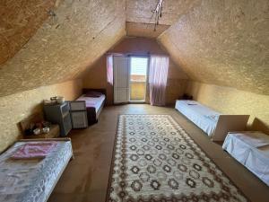 an attic room with two beds and a rug at Иртыш in Borovoye