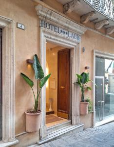 a mirror on the side of a building with two plants at Hotel Lauri in Macerata