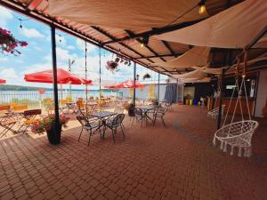 a patio with tables and chairs and red umbrellas at Domek - Carineczka Chańcza in Chańcza