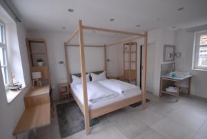 - une chambre avec un lit à baldaquin et une table dans l'établissement Bella Riva Hotel, à Marktheidenfeld