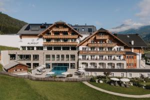 duży budynek z basenem i ośrodkiem w obiekcie ALMGUT - Mountain Wellness Hotel w mieście Sankt Margarethen im Lungau