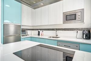 una cocina con encimeras blancas y armarios azules en Atalaya, en Almuñécar