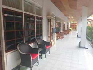 a row of chairs sitting outside of a building at Hotel Wisata in Labuan Bajo +7 photos