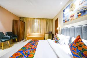ルディヤーナーにあるFabHotel Supreme Suitesのベッドと椅子のあるホテルの部屋
