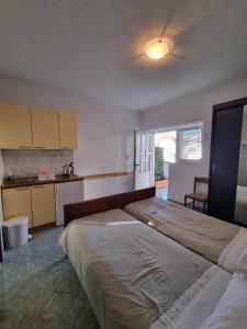 a large bedroom with two beds and a kitchen at Apartmani Bada in Pakoštane