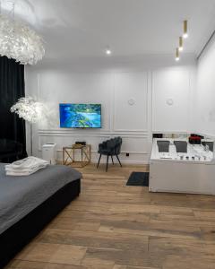 a white room with a bed and a couch and a table at Apartament Shine Prywatne Jacuzzi Starowiślna Kraków in Kraków