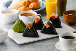 a plate of sushi with two cups of coffee at Toyoko Inn Osaka Tsutenkaku Mae in Osaka