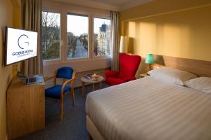 a hotel room with a bed and a tv at Hotel Parc Belle-Vue in Luxembourg