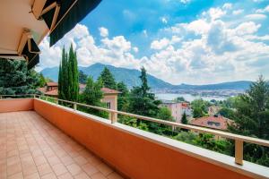 a balcony with a view of the water and mountains at JOIVY Villa Sofia in Como +37 photos