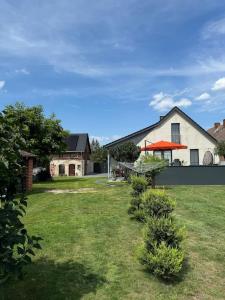 ein Haus mit einem Garten mit Büschen davor in der Unterkunft Cottbus Merzdorf Bauernhaus Ferienhaus in Cottbus