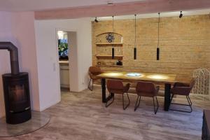 ein Esszimmer mit einem Tisch, Stühlen und einem Holzofen in der Unterkunft Cottbus Merzdorf Bauernhaus Ferienhaus in Cottbus + 21 Fotos