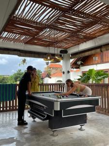a man and a woman playing a game of pool at Nyaman Hostel in Canggu