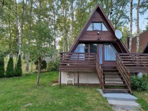 a small house with a porch and stairs to it at Cabana Ińsko-domek 20 metrów od plaży in Ińsko