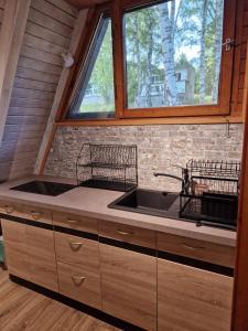 a kitchen with a sink and a window at Cabana Ińsko-domek 20 metrów od plaży in Ińsko