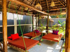 a porch with three beds with red and blue pillows at Villa Rosa in Moshi