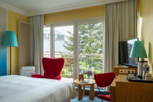 una camera d'albergo con un letto e una grande finestra di Hotel Parc Plaza a Lussemburgo