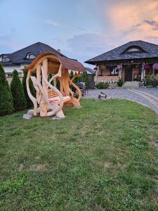 eine Holzbank im Gras vor einem Gebäude in der Unterkunft Cabana Raul in Gura Humorului + 9 Fotos