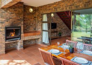 a patio with a table and a fireplace at Olifants River Lodge by Dream Resorts in Middelburg
