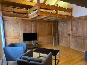 a living room with a loft bed and a tv at Sonne in Klosters