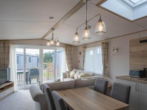 a living room with a couch and a table at Pinewoods Beach Luxe no.2 – dog friendly in Wells next the Sea