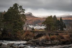 a house on the side of a river with a mountain at The Church Tower in Crieff