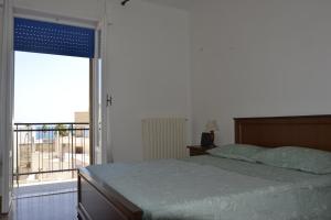 a bedroom with a bed and a large window at Puglia Meravigliosa in Mola di Bari