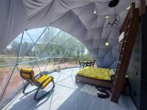 a room with a tent with a bed and chairs at Ēdelveisi Lauku sala in Līvbērze