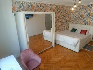 アンヌマスにあるGrande chambre d'hôte Lit king size - 3 mins Gare Annemasse - Genève accès directのベッドルーム(鏡、ベッド、椅子付)