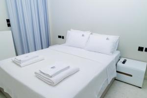 a white bed with white towels on top of it at city chic penthouse in Thessaloniki