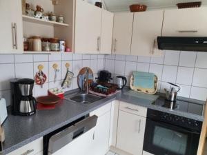 a kitchen with white cabinets and a sink at Casa Ulla am Hallenbad in Haiger