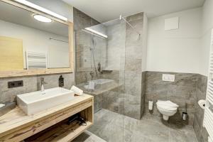 a bathroom with a sink and a shower and a toilet at Das Förstereck in Viehhofen +41 photos