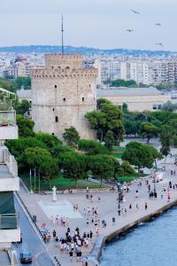 a group of people walking on a sidewalk in front of a castle at city chic penthouse in Thessaloniki