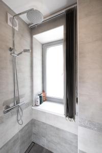 bagno con doccia e finestra di Centra apartamenti Elīza a Limbaži