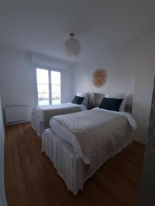 a bedroom with two beds and a window at Garden Alley House 8 personnes in Serris