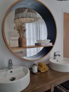 a bathroom with a round mirror above a sink at Garden Alley House 8 personnes in Serris