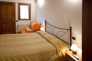 - une chambre avec un lit et une chaise orange dans l'établissement Country House Carfagna, à Assise