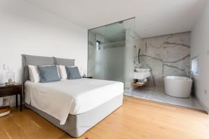 a bedroom with a large white bed and a bathroom at Ocean Blue in Paphos City +17 photos